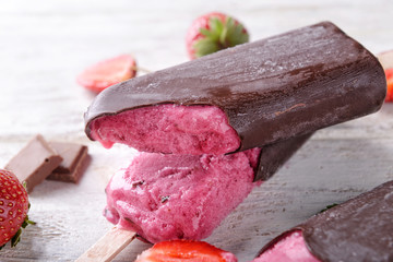 Tasty strawberry ice-cream with chocolate on table, closeup