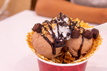Chocolate ice cream in the red cup on the table.