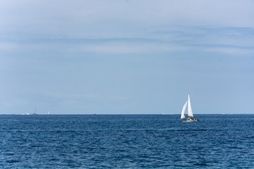 Obraz premium Sailboat glides across the bright blue ocean