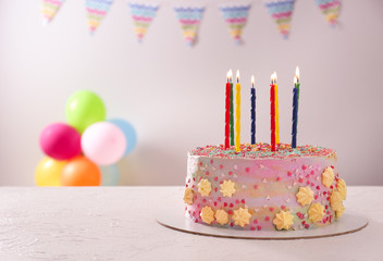 Beautiful tasty birthday cake with candles on white table