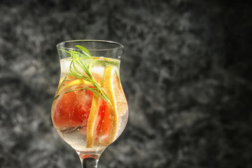 Fresh grapefruit cocktail with rosemary in glass on grey background