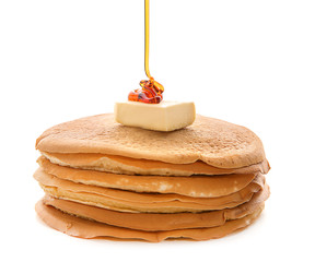 Pouring of honey onto delicious pancakes against white background