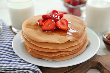 Plate with delicious pancakes, honey and strawberries on table, closeup