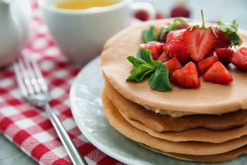 Plate with delicious pancakes and strawberries on table, closeup