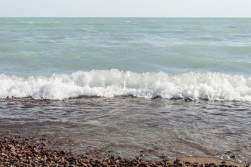 Beautiful sea waves hitting the pebble beach.
