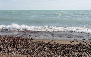Beautiful sea waves hitting the pebble beach.