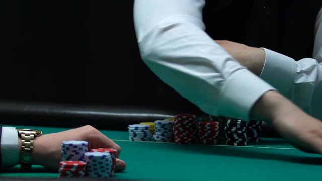 Casino dealer spreading card deck in front male player, entertainment business