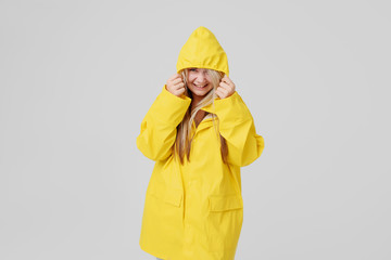 Woman in a yellow raincoat on a gray background