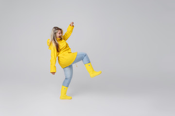 Woman in a yellow raincoat on a gray background