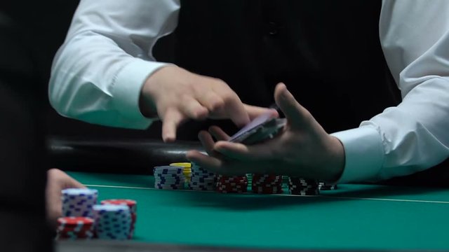 Poker dealer masterfully shuffling cards, casino entertainment business, slow-mo