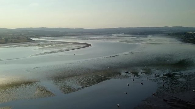 Lympstone, England. Rising aerial pan. Low tide, sunset, sunrise.