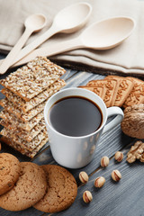 Cup of hot coffee assorted with cookies for breakfast on wooden vintage gray table.