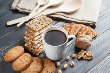 Cup of hot coffee assorted with cookies for breakfast on wooden vintage gray table.