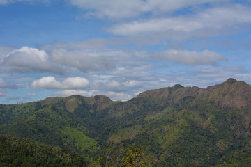 Beautiful mountain landscape, with mountain peaks covered with forest and a cloudy sky
