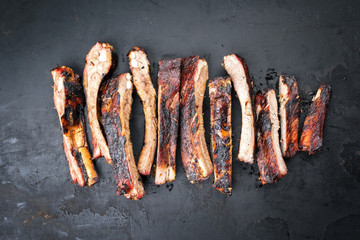 Barbecue spare ribs St Louis cut with hot honey chili marinade sliced as top view on an old rustic...