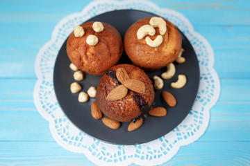 Delicious homemade chocolate muffins on the blue vintage wooden background.