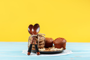 Delicious homemade chocolate muffins on yellow and blue vintage background.