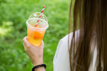 Natural fruit lemonade in the hands of a girl