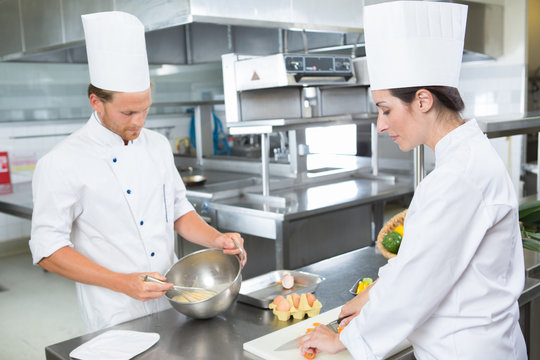 Male and female chefs prepping