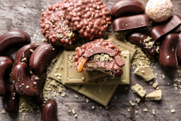 Delicious chocolate with candies and cookies on wooden table