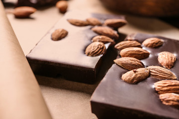 Delicious chocolate with almonds on parchment, closeup