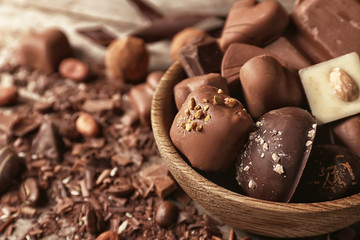 Bowl with yummy chocolate candies on table, closeup