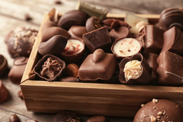 Box with yummy chocolate candies on table