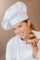 Baker holding some profiteroles