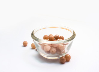 Light orange color sunstone isolated in Glass cup on white background