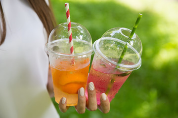 Natural fruit lemonade in the hands of a girl