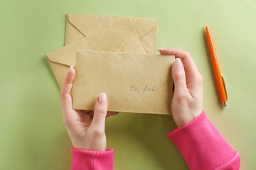 Woman holding envelope on color background