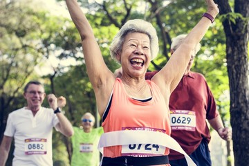 Fototapeta premium Happy senior running through the finish line