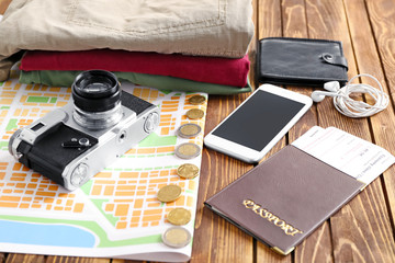 Composition with passport, map, camera and mobile phone on wooden background. Travel concept