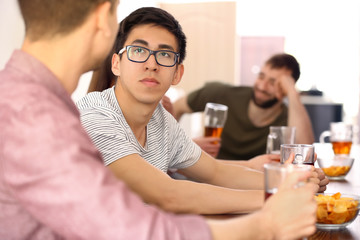 Man with friends drinking beer in bar