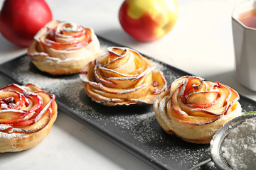 Plate with tasty rose shaped apple pastry on table
