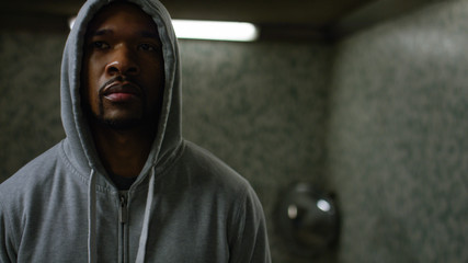 Portrait of male in hood in a tunnel with space for text