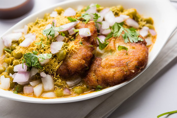 Ragda Pattice is a popular Street food or chat made of potato Patties. served in a steel plate, bowl or ceramic plate with tamarind and cilantro chutney