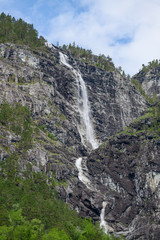Fototapeta na wymiar View of a waterfall from the fjord. Neroyfjord offshoot of Sognefjord is the narrowest fjord in Europe. Norway.