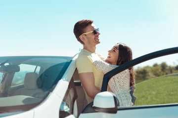 Beaming woman. Dark-haired beaming woman hugging her good-looking husband while traveling together