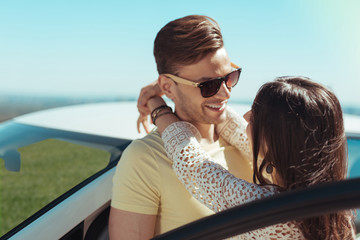 Dark-haired man. Dark-haired man wearing sunglasses looking at his wife while standing near his...