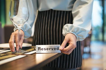 Hand with Reserved Table. Elegant Restaurant Table Setting Service for Reception with Reserved Card.