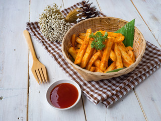 French fried barbeque flavour in wood basket on white wood table.