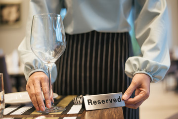 Hand with Reserved Table. Elegant Restaurant Table Setting Service for Reception with Reserved Card.