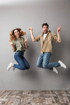 Full length portrait of an excited young couple jumping