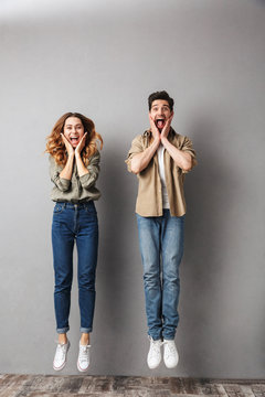 Full length portrait of an excited young couple jumping