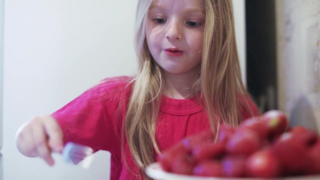 Girl child eating strawberries