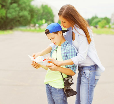 Mother With Child Tourists Sightseeing City With A Paper Map