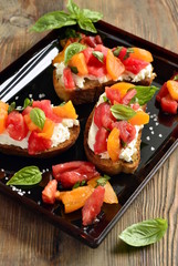 Italian bruschetta with chopped tomatoes, basil and cheese on crusty bread, vertical 