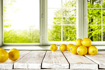 fresh yellow lemon on desk and window background with summer garden. Free space for your glass. 