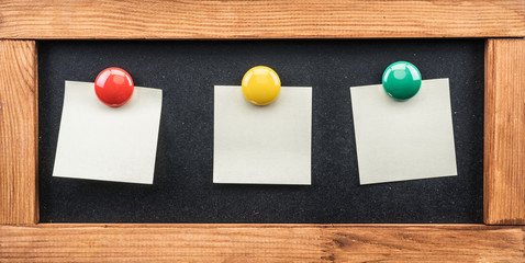 Blackboard and post-it notes stuck with colorful magnets.